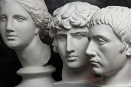 Gypsum copy of ancient statue Germanicus, Antinous and Venus head on dark textured background. Plaster sculpture face.